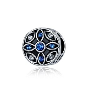 Détail d'une perle de charme en argent avec cristaux bleus et motif floral en émail noir