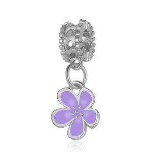 Macro detail of a silver floral charm featuring purple enamel petals and crystal accents