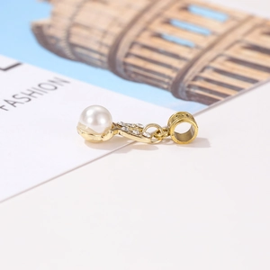 Detailed close-up of a gold rabbit charm with a lustrous white pearl and sparkling crystals