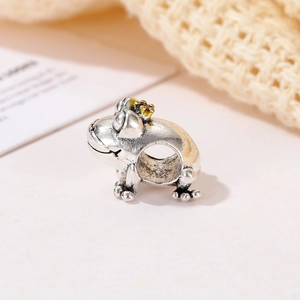 Gros plan détaillé d'une perle de charme grenouille vintage avec petite couronne dorée