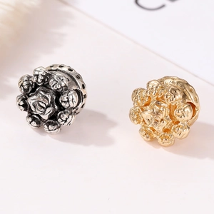 Macro shot of rose flower beads in vintage silver and gold finish for DIY bracelets