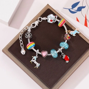Detailansicht eines DIY-Bettelarmbands mit Einhorn- und Herzanhängern auf einer Displaybox