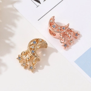 Detail von Mond- und Sternanhängern in Gold und Roségold mit blauen Strasssteinen für DIY