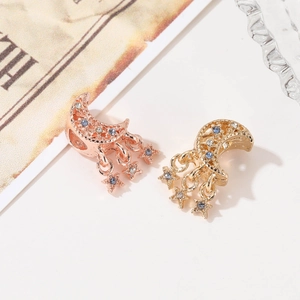 Detailansicht von Mond- und Sternanhängern mit blauen Zirkonia in Gold und Roségold