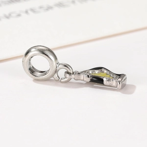 Detailed macro view of silver harp musical instrument charm with black and yellow enamel