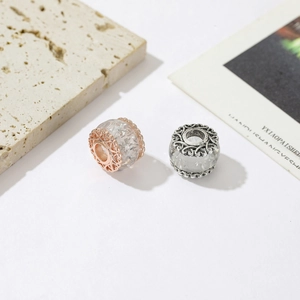 Rose gold and silver charms with hollow flower patterns and sparkling glass beads