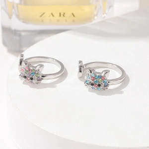 Verstellbare silberne Katzenringe mit bunten Kristallen auf weißem Sockel, eleganter Schmuck
