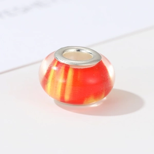 Macro view of handmade red and yellow flow glass bead with silver metal core