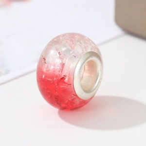 Detailed view of red and white gradient crackle glass charm bead with silver metal core