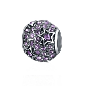 Détail macro du charm sphérique en argent avec cristaux violets et motifs d'étoiles