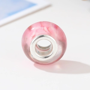 Macro detail of translucent pink resin bead with silver core for DIY jewelry