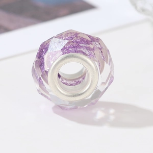 Macro shot of faceted purple resin bead with glitter and silver metal core detail
