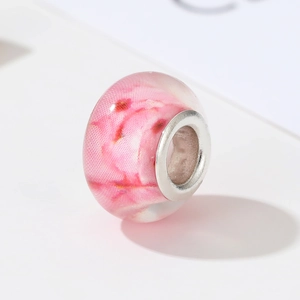 Macro shot of transparent pink flower charm bead with silver metal core for DIY bracelets