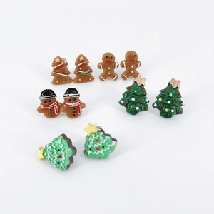 Detail of five pairs of resin Christmas earrings featuring gingerbread men and trees