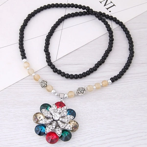 Collana in stile etnico con pendente floreale e pietre colorate su catena di perle nere