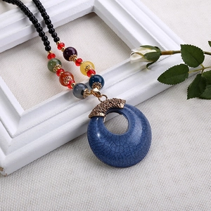 Dettaglio di collana etnica con ciondolo blu effetto craquelé e perline colorate miste