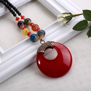 Dettaglio della collana bohémien con perline colorate e grande pendente ad anello rosso
