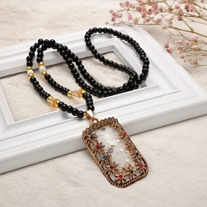 Boho-Perlen-Pulloverkette mit Vintage-Blumen-Hohlanhänger und bunten Strasssteinen