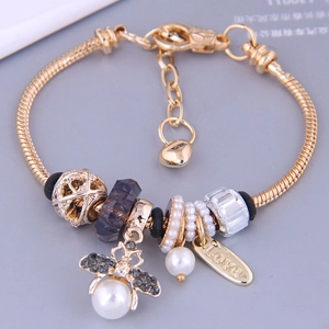Golden snake chain charm bracelet with purple beads, bee pendant and pearl accents