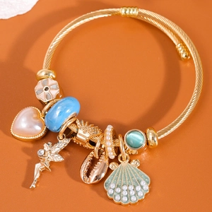 Bracciale a cavo dorato con cuore rosa, perla blu e ciondoli a forma di angelo