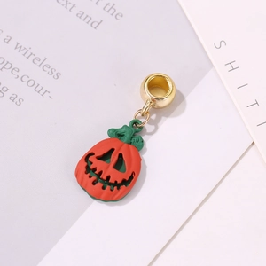 Dettaglio di un ciondolo a zucca di Halloween in smalto arancione con anello in metallo dorato