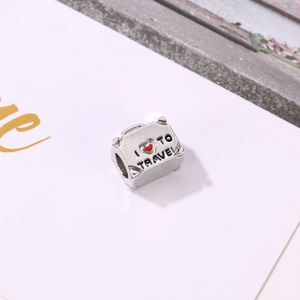 Detail of silver suitcase charm with red heart and I Love to Travel engraving