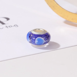 Macro detail of blue glass heart bead with silver glitter for DIY jewelry bracelet
