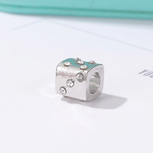 Detailed view of silver cube spacer bead with textured surface and sparkling rhinestones
