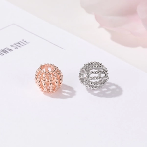 Detalle de cuentas huecas en oro rosa y plata con diseño de textura de perlas