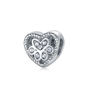 Detail view of heart-shaped pet paw bead with sparkling zircons and silver metal texture