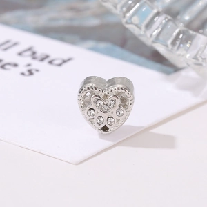 Macro shot of a heart-shaped silver charm with sparkling stones in a paw print design