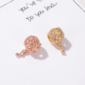 Detalle de dijes de notas musicales en oro rosa y oro con símbolos de clave de sol huecos