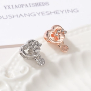 Macro detail of heart charm with paw print and Fur Mom engraved disc in rose gold and silver