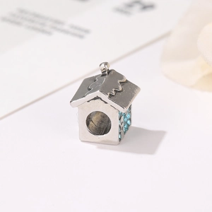 Vista macro di charm a casa in argento con strass azzurri per collane fai-da-te