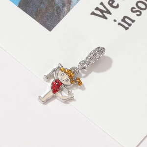 Macro shot of a cartoon girl charm with red and yellow rhinestones for DIY jewelry