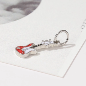 Macro detail of electric guitar pendant with red and white enamel finish for jewelry making