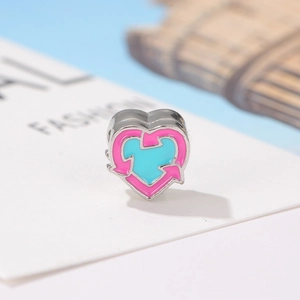 Détail d'une breloque en forme de cœur avec émail rose et bleu et silhouette de dessin animé