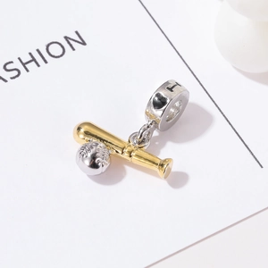 Macro view of gold baseball bat and silver ball charms on a heart patterned bead