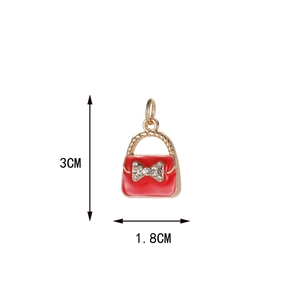 Detailed view of red enamel handbag charm with bow showing 3cm by 1.8cm dimensions