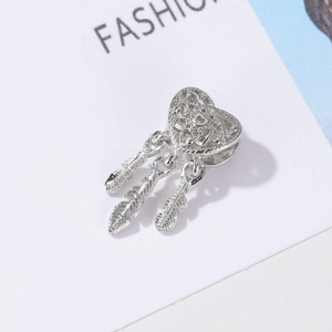 Detailed view of silver heart-shaped dreamcatcher charm with three delicate feathers