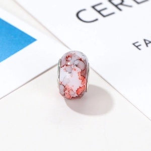 Detail der DIY-Resin-Perle mit roter Tinten-Marmorierung und silbernen Metallkernen