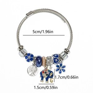 Detailed view of silver wire bracelet with blue elephant pendant and tree of life charm