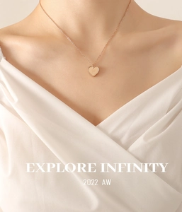 Détail du collier cœur en or rose avec bordure perlée et gravure porté par un mannequin
