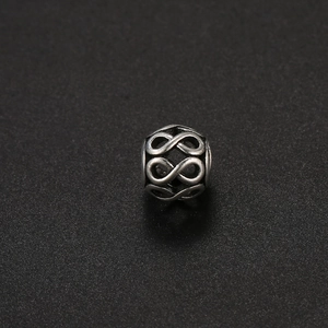Detalle macro de una cuenta hueca de plata antigua con símbolo de infinito para joyería