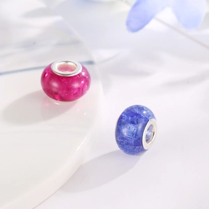 Detailed close-up of macaron-colored resin beads with crackle texture and metal core