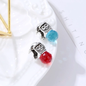 Detail of vintage silver Santa Claus charms with faceted red and blue glass beads