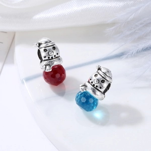 Close-up of snowman charms with faceted red and blue crystal beads for DIY jewelry