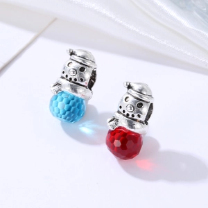 Macro shot of snowman crystal charms with faceted blue and red beads for jewelry