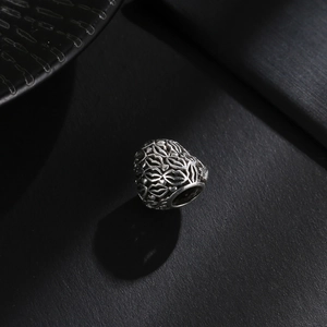 Detalle macro de cuenta hueca de plata antigua con patrón de hojas para joyería artesanal