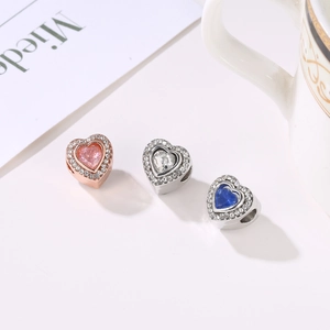 Macro view of three heart-shaped beads with multi-color rhinestones for DIY jewelry